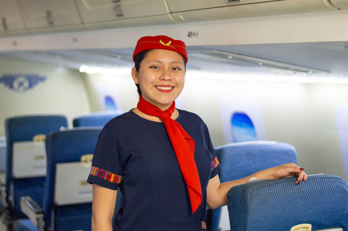 Tripulante de cabina sonriendo dentro del avión