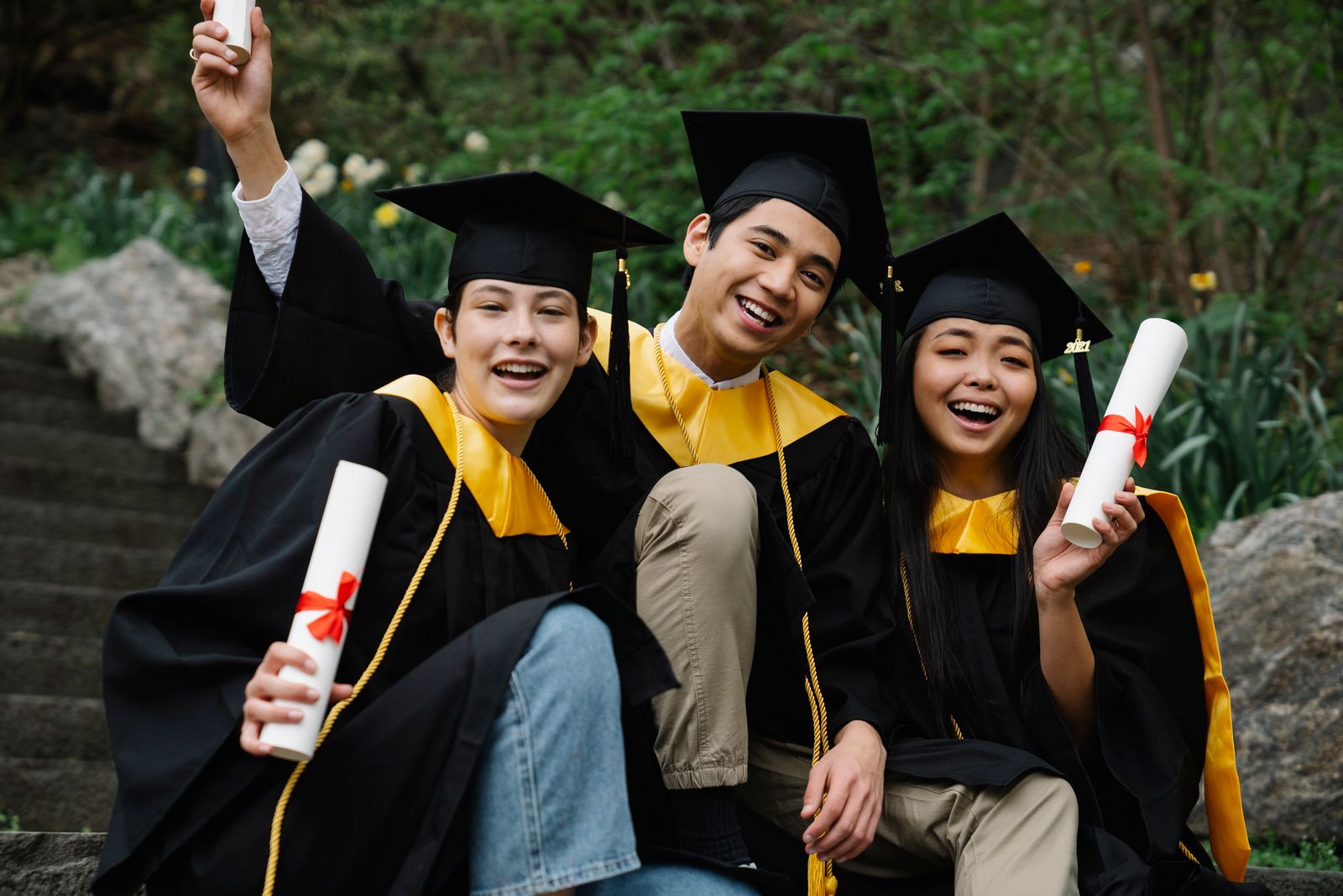 Graduados celebrando con sus diplomas tras certificar su inglés